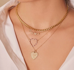 Detailaufnahme mehrlagiger Herzketten in Gold mit MAMA-Anhänger und Zirkoniasteinen