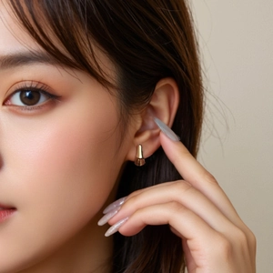 Close-up of geometric gold S925 silver hoop earrings on a model showing modern polished finish