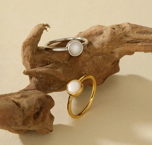Detailed view of elegant 925 sterling silver rings with white shell on natural wood