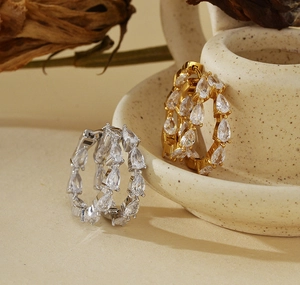 Macro shot of S925 sterling silver hoop earrings with pear-cut cubic zirconia in gold and silver
