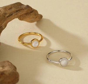 Detailed close-up of 925 silver rings with white shell inlay in gold and silver finish