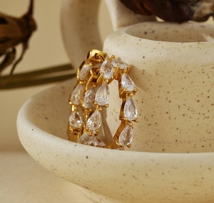 Detailed close-up of gold S925 silver hoop earrings with pave pear-cut cubic zirconia