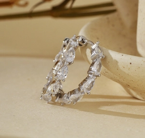Detailed view of S925 silver hoop earrings featuring pear-cut cubic zirconia stones