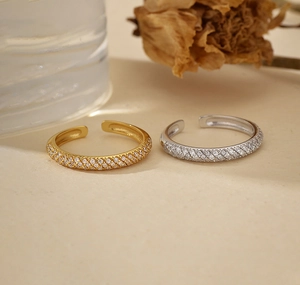 Detail of silver and gold adjustable open rings with sparkling cubic zirconia pavé