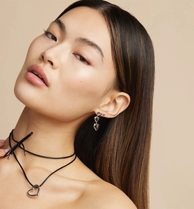 Close-up of S925 silver heart dangle earrings and black choker on female model