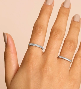 Close-up of stacked S925 sterling silver rings with round and baguette diamonds