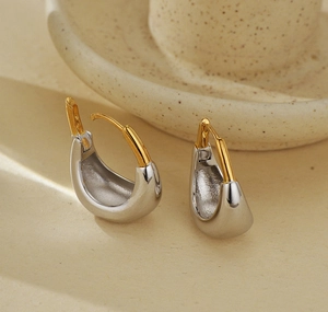 Gros plan de boucles d'oreilles bicolores en argent S925 en forme de U avec fermoirs dorés