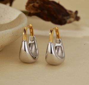 Vue macro des boucles d'oreilles créoles bicolores or et argent avec finition polie