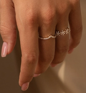 Détail de bagues superposées en argent 925 avec zircons en forme de V dorés
