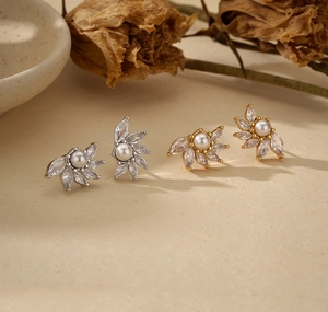 Détail de boucles d'oreilles perles argent et or avec zircons en forme d'éventail élégant