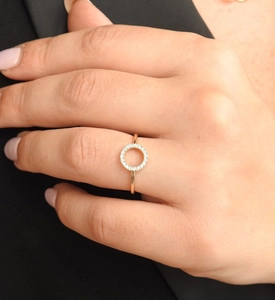 Gros plan d'une bague en or minimaliste avec pavé de diamants sur un dessus rond en forme de O