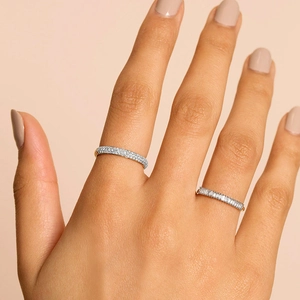 Eternity bands in 18K gold plating with round and baguette-cut diamonds on hand