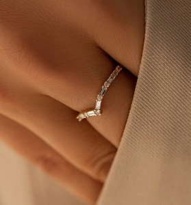 Vue macro d'une bague dorée en V avec cristaux rectangulaires et ronds alternés