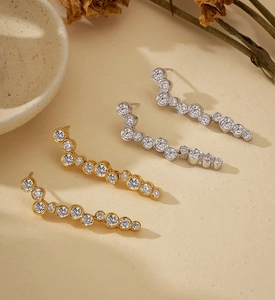 Detailed view of silver and gold curved stud earrings with round cubic zirconia rows