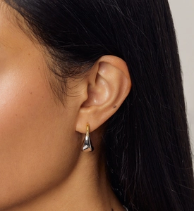 Gros plan de boucles d'oreilles goutte bicolores en argent S925 portées par un mannequin