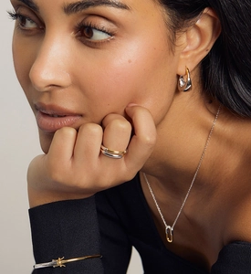 Gros plan sur un collier bicolore élégant et des boucles d'oreilles en U sur mannequin