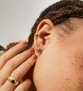 Detail of 925 sterling silver gold layered cuff and pave diamond earrings on model