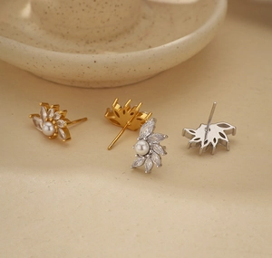 Gros plan sur des boucles d'oreilles en perles dorées et argentées ornées de zircons brillants