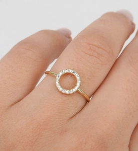 Gros plan d'une bague creuse en forme d'O sertie de diamants et dorure polie