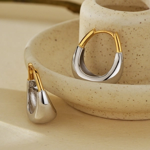 Boucles d'oreilles bicolores fer à cheval en argent et or poli sur plateau céramique