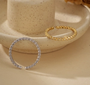 Dettaglio di anelli in argento S925 placcati oro 18K con bordo a microsfere e zirconi