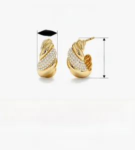 Close-up of twisted 925 sterling silver earrings with inlaid cubic zirconia and gold plating