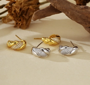 Close-up of gold and silver twisted hoop earrings with micro-set cubic zirconia stones