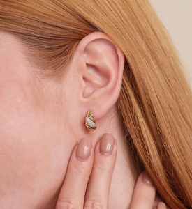 Close-up of luxury twisted gold stud earring with sparkling cubic zirconia on model