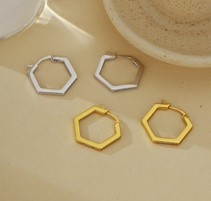 Detailed macro view of S925 silver and gold hexagonal earrings with pavé cubic zirconia