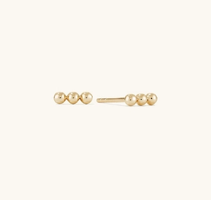 Close-up of polished 925 silver stud earrings with a minimalist triple golden bead design