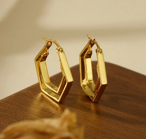 Close-up of geometric double hoop earrings with a polished gold finish and snap closure