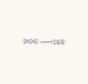Close-up of minimalist 925 silver stud earrings featuring three polished metal beads