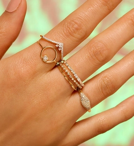 Dettaglio di un set di anelli a fascia in oro 18K con design a serpente e pietre di zircone