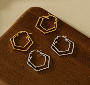 Macro shot of S925 stamped double geometric hexagonal hoop earrings in gold and silver