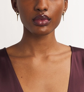 Close-up of gold S925 silver rivet earrings with micro-pave crystals on a model