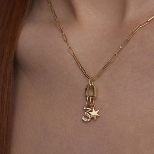 Macro detail of gold S925 sterling silver star pendant and diamond number 3 on paperclip chain