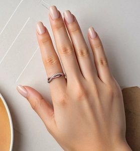 Detail of interlocking rose gold and diamond bands on woman's middle finger
