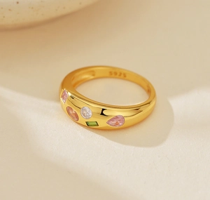 Macro del marchio S925 e zirconi colorati incastonati sull'anello in argento dorato