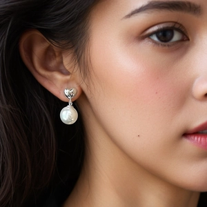 Elegant S925 sterling silver heart-shaped stud earrings with white pearl drops on model