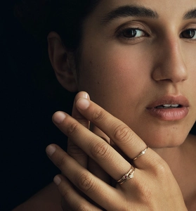 Macro detail of gold rings with sparkling diamonds and ruby stone on model's hand