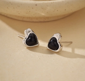 Detail shot of heart-shaped S925 sterling silver earrings with black onyx inlay