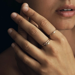 Elegant gold stackable rings set with ruby heart and small diamond on model's hand