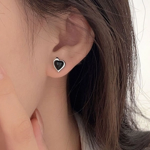 Elegant S925 sterling silver heart earrings with black onyx on a female earlobe