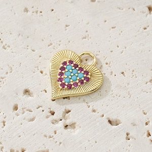 Detailed macro view of heart-shaped gold pendant with colorful zircon stones and solar texture