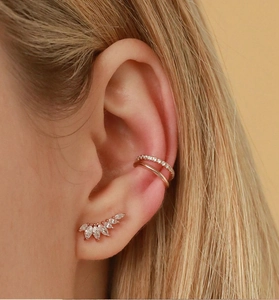 Détail de la boucle d'oreille aile en or rose et de la bague d'oreille avec zircons