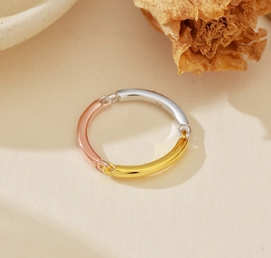 Detail of tricolor 925 silver ring featuring intertwined gold, rose gold and silver bands