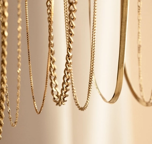Gros plan détaillé montrant diverses textures de colliers dorés avec mailles variées