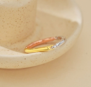 Macro shot of tricolor 925 silver ring with 18k gold and rose gold interlaced bands