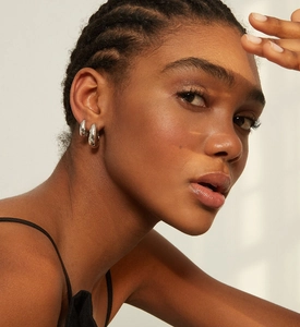 Vue macro de boucles d'oreilles en U argentées avec diamants portées par un mannequin