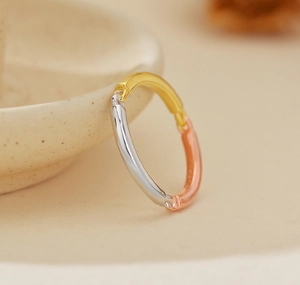 Detailed close-up of minimalist tricolor 925 silver ring in gold white and rose finishes